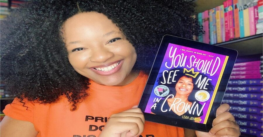 Leah Johnson holding one of the books to read during Pride Month
