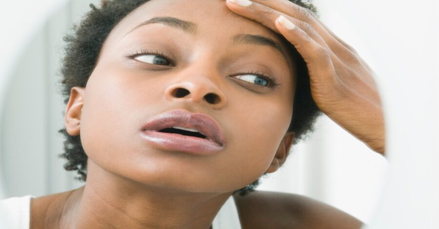 Black woman looking at herself in the mirror