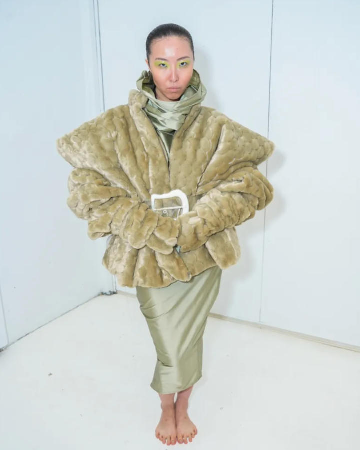 Model wearing a jade dress and coordinating coat designed by Joseph McRae.