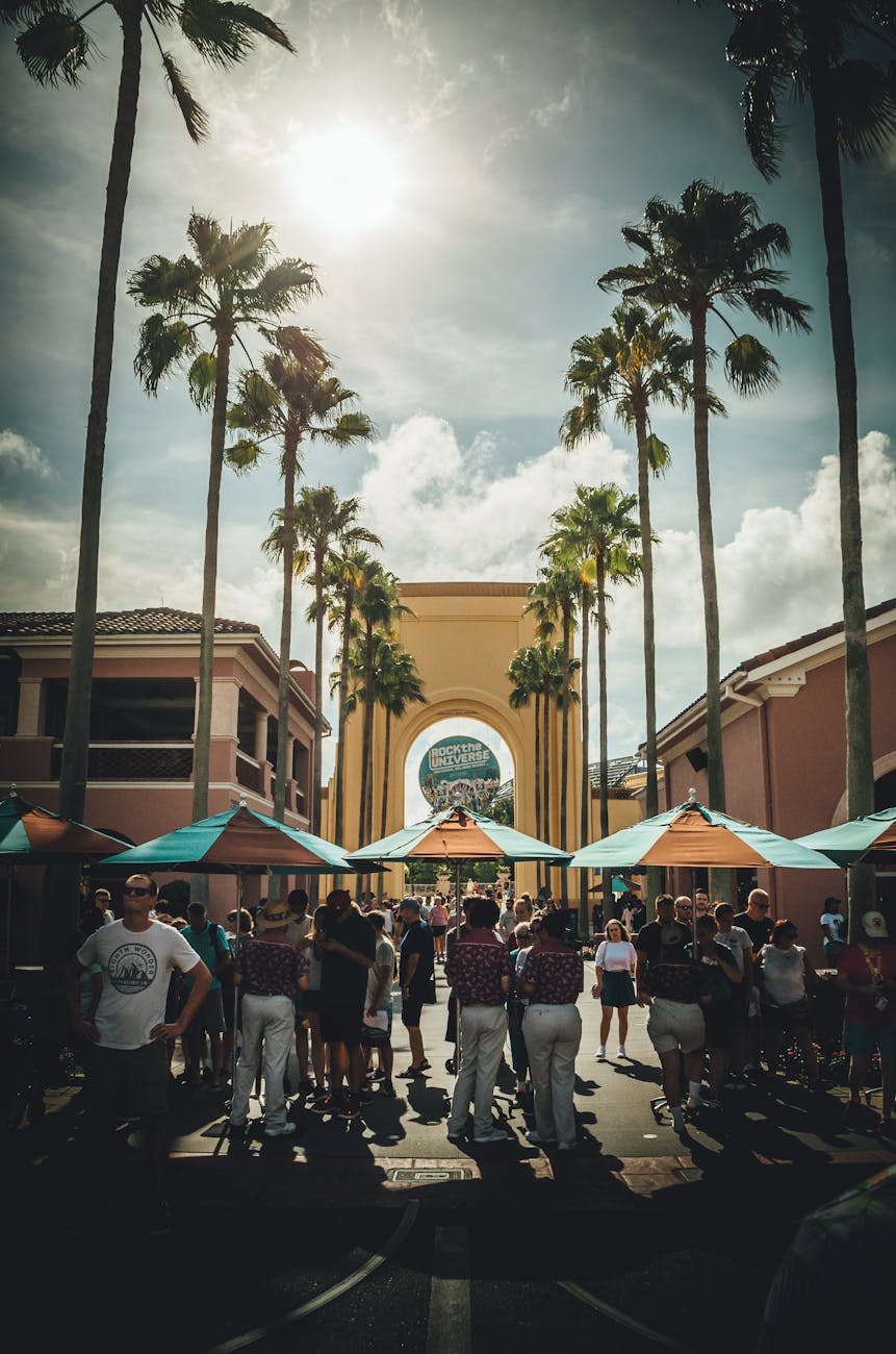 people standing in between trees near buildings during daytime