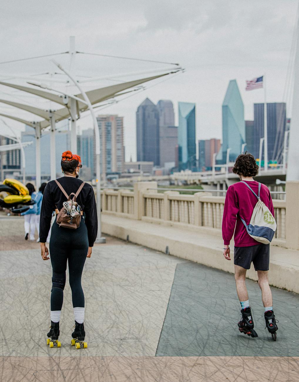 friends roller skating on bridge in big city