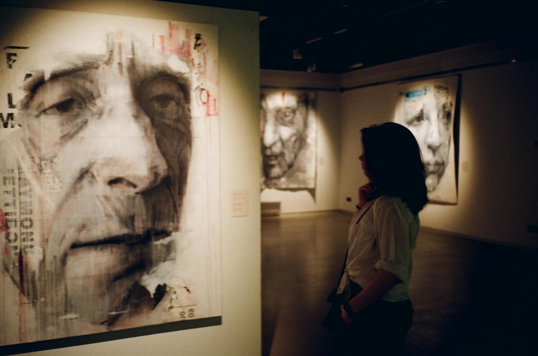 woman standing in front of man s painting